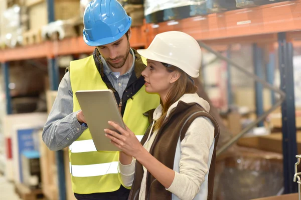 Gerente com warehouseman verificando níveis de estoque — Fotografia de Stock