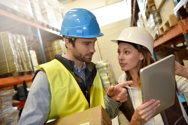Manager with warehouseman checking stock levels — Stock Photo, Image