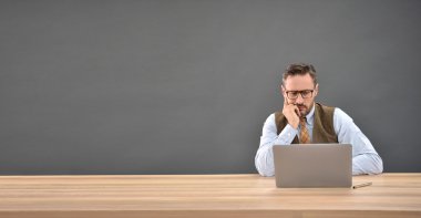 laptop önünde oturan adam
