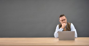 laptop önünde oturan adam