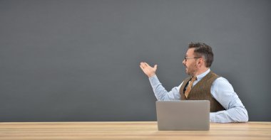 laptop önünde oturan adam