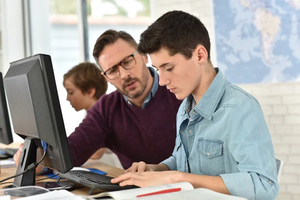 Lärare i computing klass hjälpa tonåring — Stockfoto