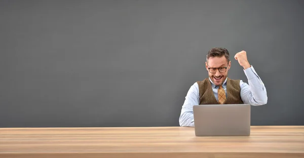 Geschäftsmann mit erhobener Faust vor Laptop — Stockfoto