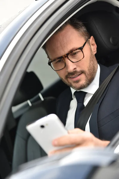 Geschäftsmann im Auto liest Nachricht — Stockfoto