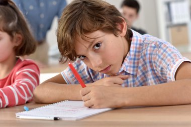 School boy in class writing clipart
