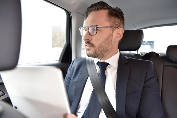 Empresario en taxi leyendo noticias —  Fotos de Stock