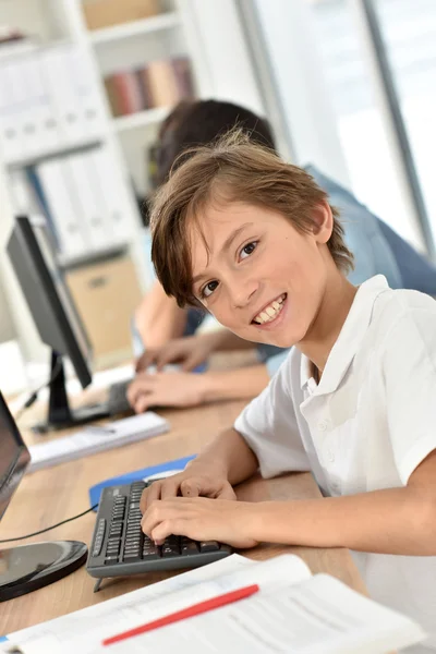 Школьник улыбается в компьютерной лаборатории — стоковое фото
