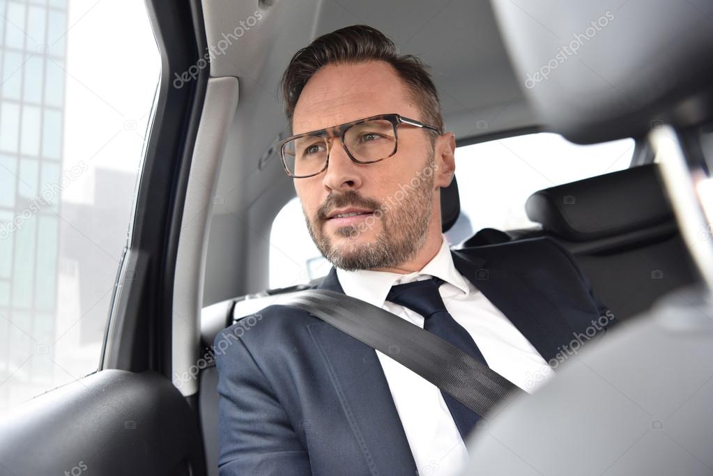 Businessman in taxi cab looking
