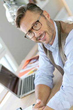 gözlük ofisinde oturan adam