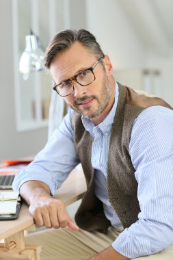 gözlük ofisinde oturan adam