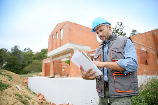 Manager überprüft Bauplan vor Ort — Stockfoto