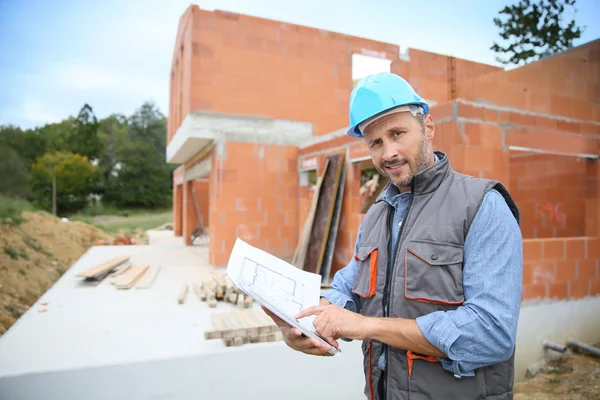 Manager checking blueprint on site — Stock Photo, Image