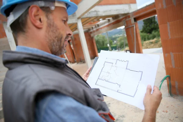 Manager checking blueprint on site — Stock Photo, Image