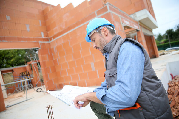 manager checking blueprint on site