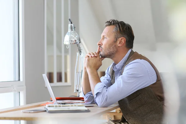 Uomo in ufficio che guarda attraverso la finestra — Foto Stock