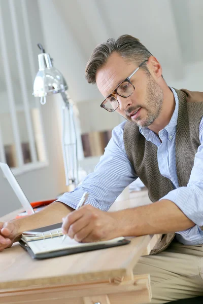 Zakenman met brillen schrijven op de agenda — Stockfoto