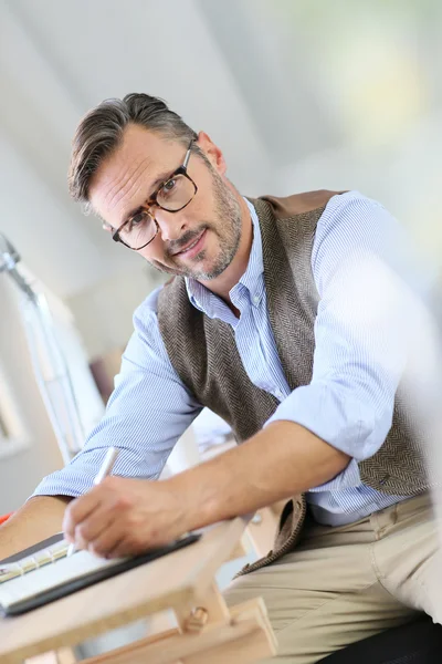 Uomo d'affari con occhiali da vista scrivere in agenda — Foto Stock