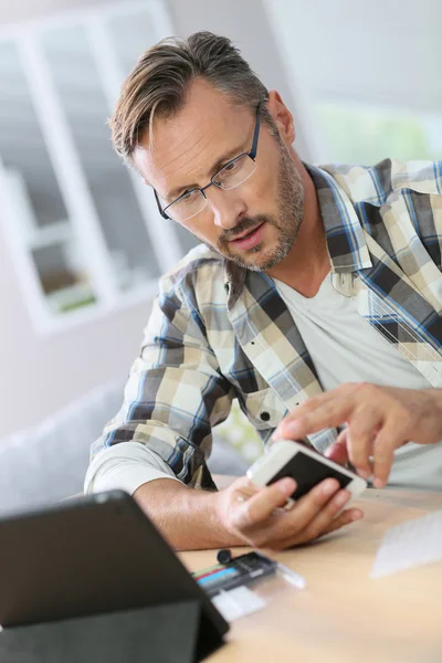 Man thuis vaststelling smartphone — Stockfoto