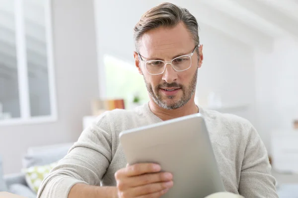 Człowiek na kanapie z tabletka — Zdjęcie stockowe