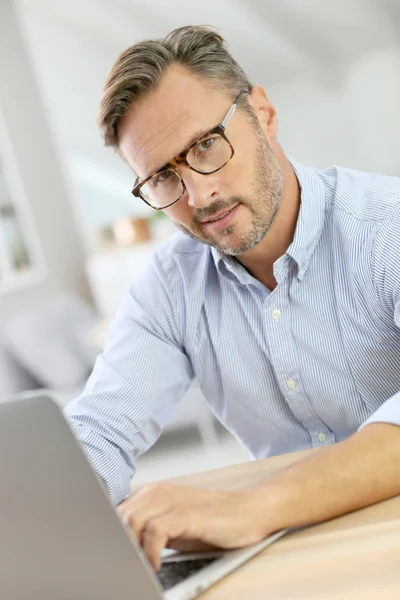 Hombre en casa usando portátil — Foto de Stock