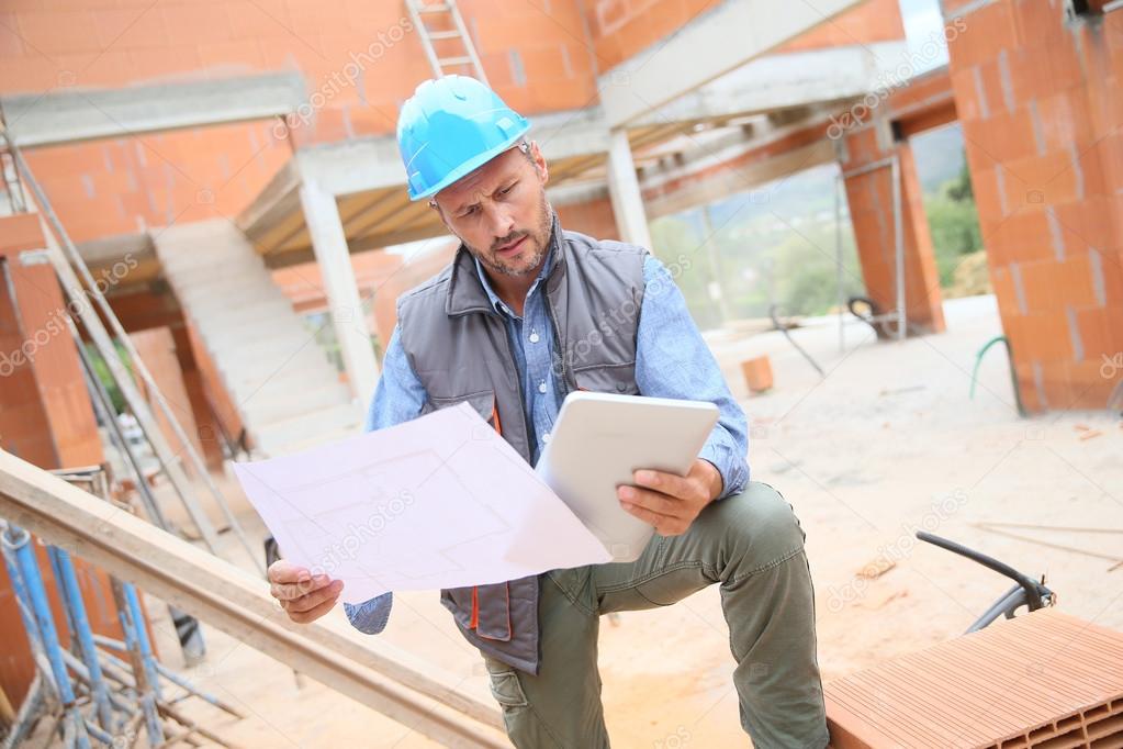 manager checking blueprint on site