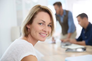 ofiste çalışan gülümseyen kadın