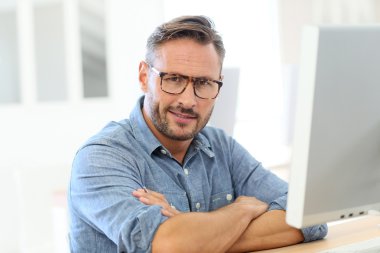 Masaüstü önünde oturan adam