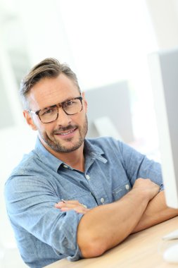 Masaüstü önünde oturan adam