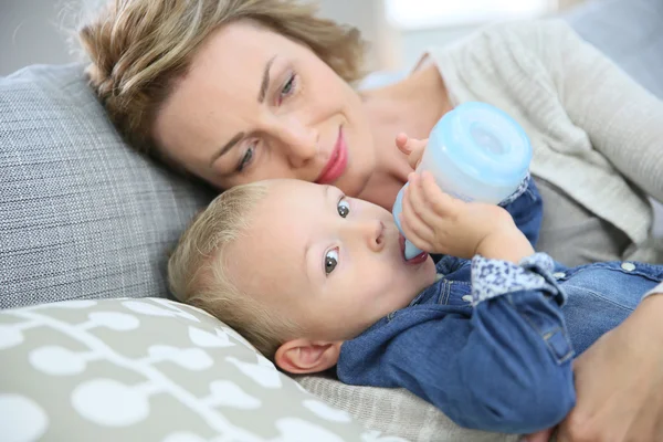 Maman regardant bébé garçon boire — Photo