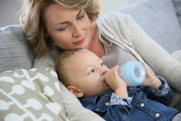 Mommy watching baby boy drinking — Stock Photo, Image