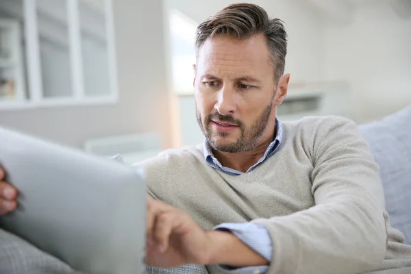 Man at home websurfing on digital tablet — Stock Photo, Image