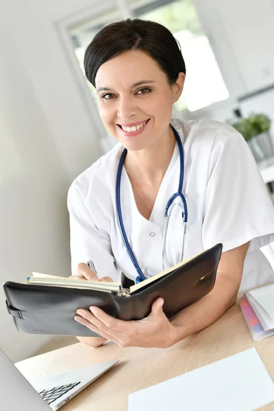 Doctor escribiendo en agenda — Foto de Stock