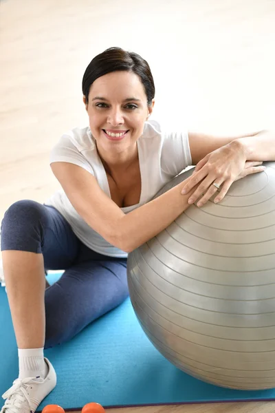 Mulher sentada por bola de fitness — Fotografia de Stock