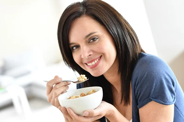 Rijpe vrouw eten granen — Stockfoto