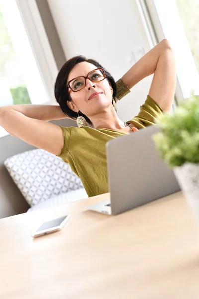 Empresária relaxante na frente do laptop — Fotografia de Stock