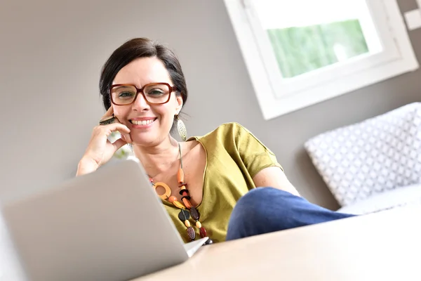 Vrouw werkt op laptop vanuit huis — Stockfoto
