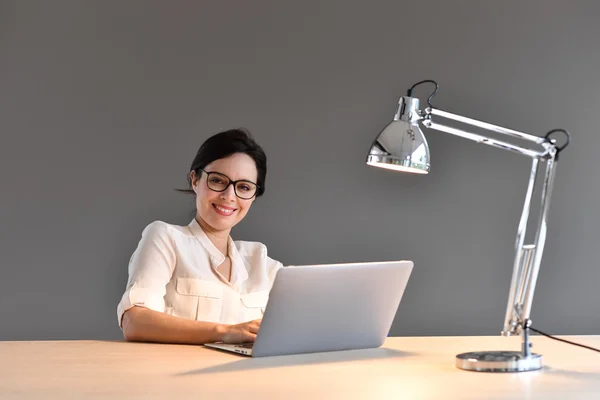 Kvinna sitter framför laptop — Stockfoto