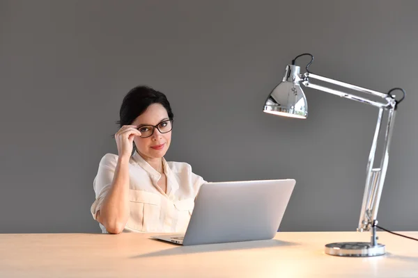 Kvinna sitter framför laptop — Stockfoto