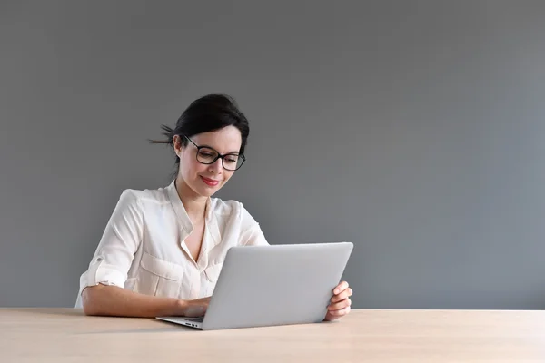 Kobieta siedząca przed laptop — Zdjęcie stockowe
