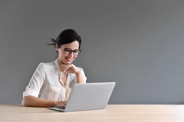 Женщина сидит перед ноутбуком — стоковое фото