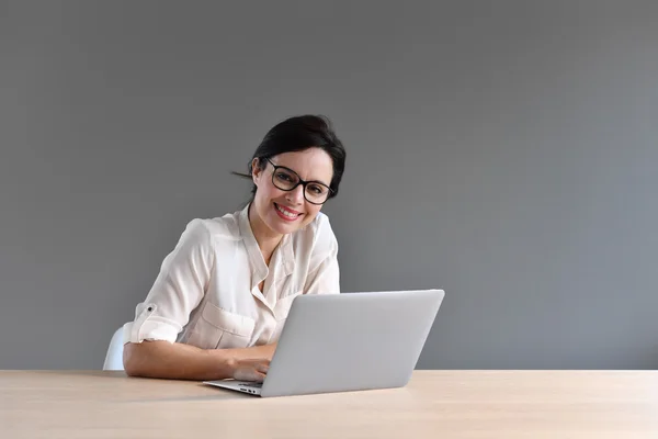 Mujer sentada frente a la laptop —  Fotos de Stock