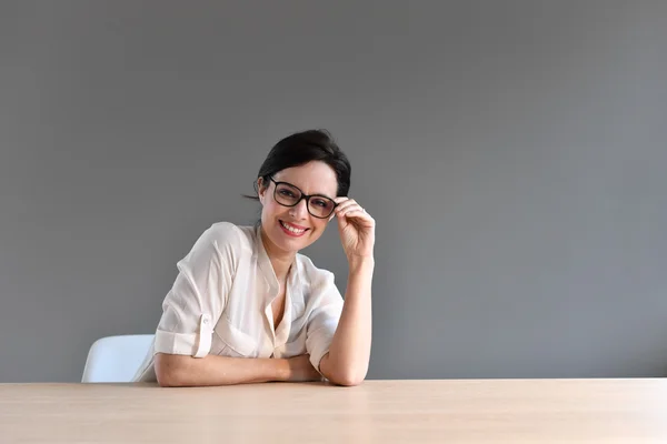 Leende affärskvinna sitter — Stockfoto