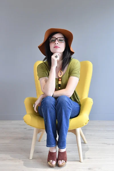 Трепетная женщина в шляпе на сидячем месте — стоковое фото