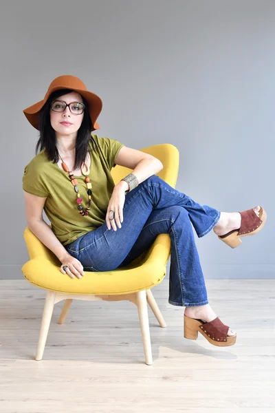 Mujer de moda con sombrero en sentado — Foto de Stock