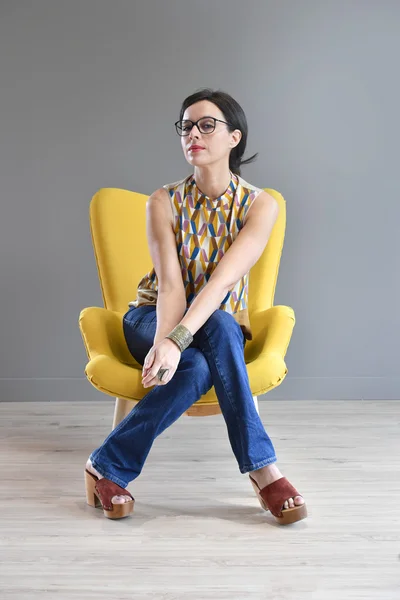 Mujer relajante en sillón amarillo —  Fotos de Stock