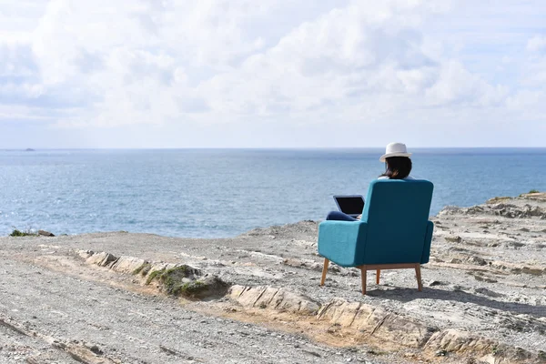 Woman using laptop by the sea — Stock Photo, Image