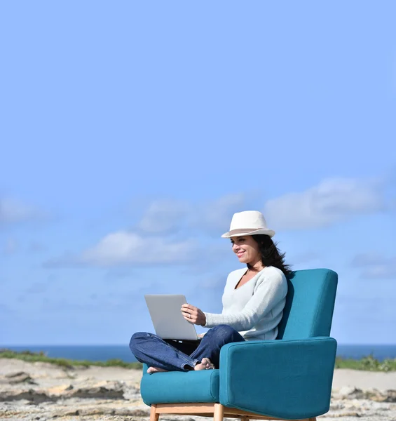 Woman using laptop by the sea — Stock Photo, Image