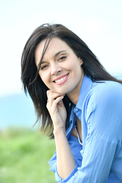Vrouw in het blauwe shirt glimlachen — Stockfoto