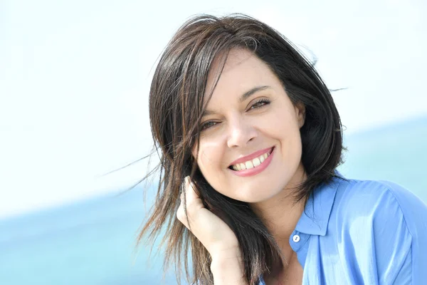 Vrouw in het blauwe shirt glimlachen — Stockfoto