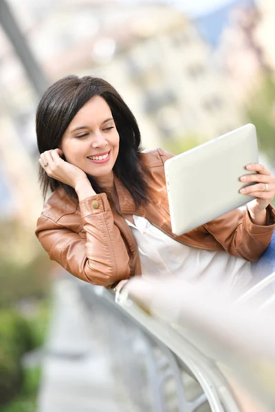 Femme assise sur un banc avec tablette — Photo